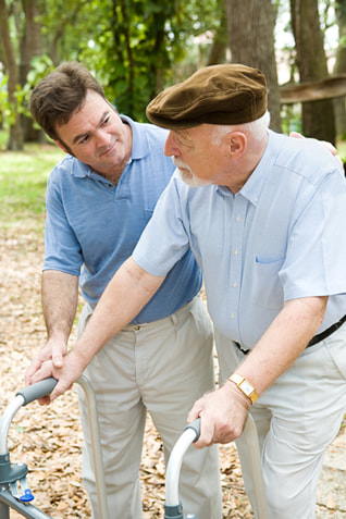A younger man helping a older senior walk with his walker