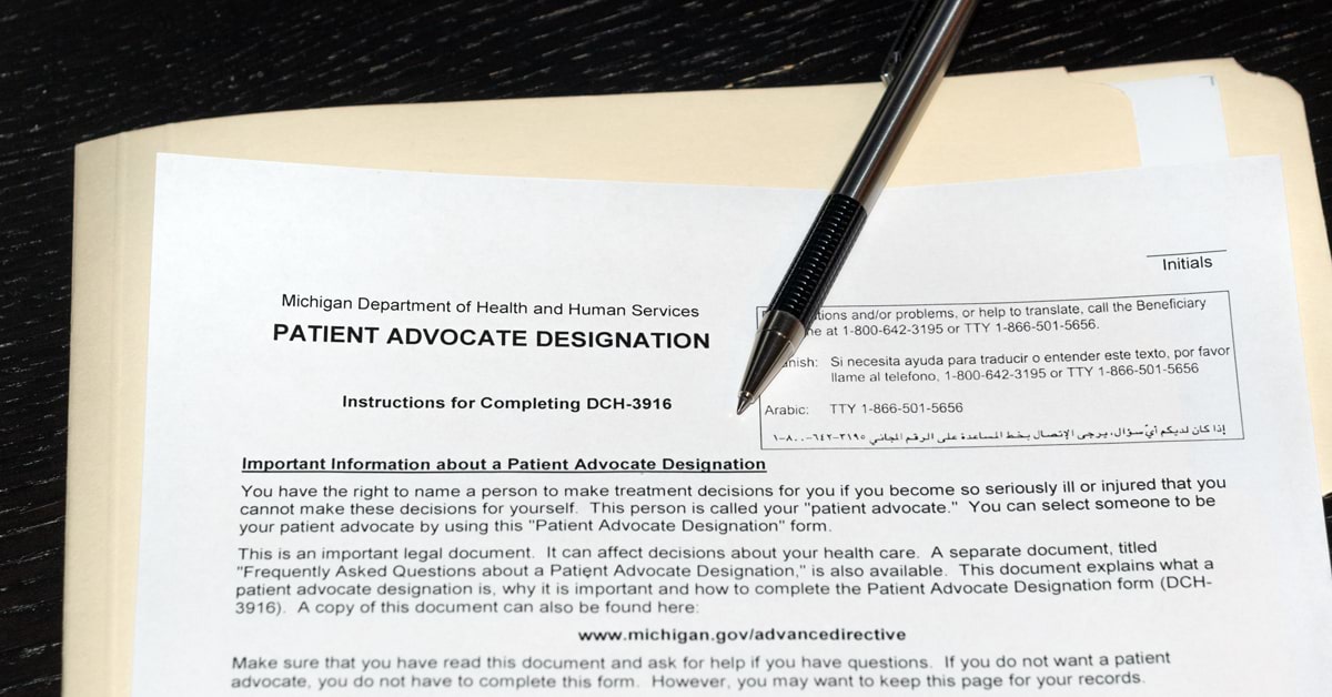 A patient advocate designation form DCH-3916 from the Michigan Department of Health and Human Services shown with a zebra mechanical pen sitting on top of a manila folder