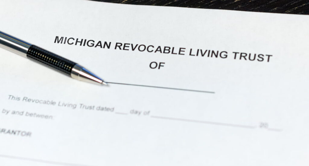 A michigan revocable living trust form is laid out on a desk with a zebra mechanical pen to the side